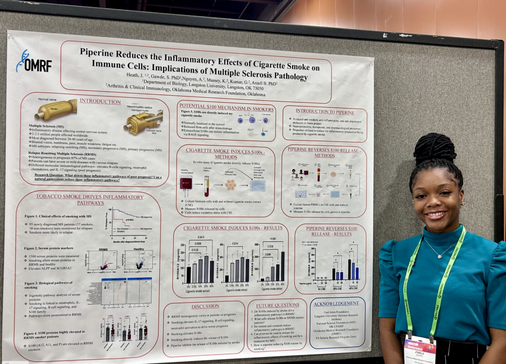J'Taelii Heath stands by poster with research data on it.